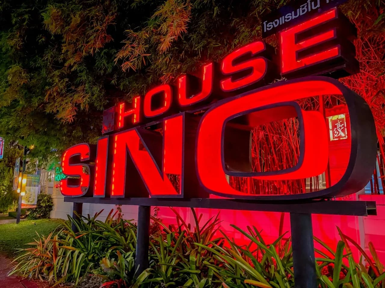 Sino House Phuket illuminated hotel sign at night